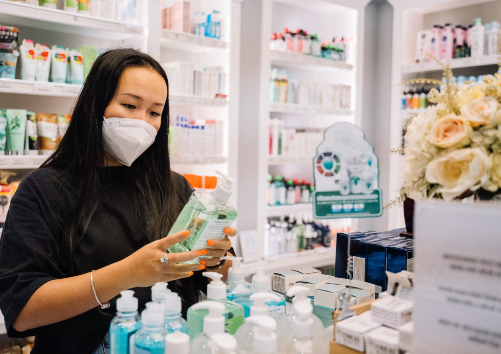 woman wearing a mask in a pharmacy holding medicines