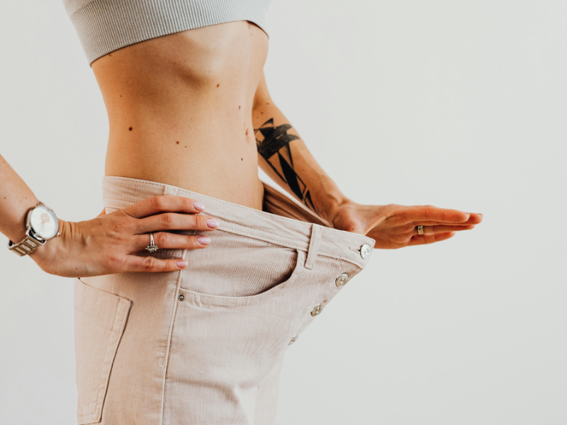 person with weight loss stretching his trousers