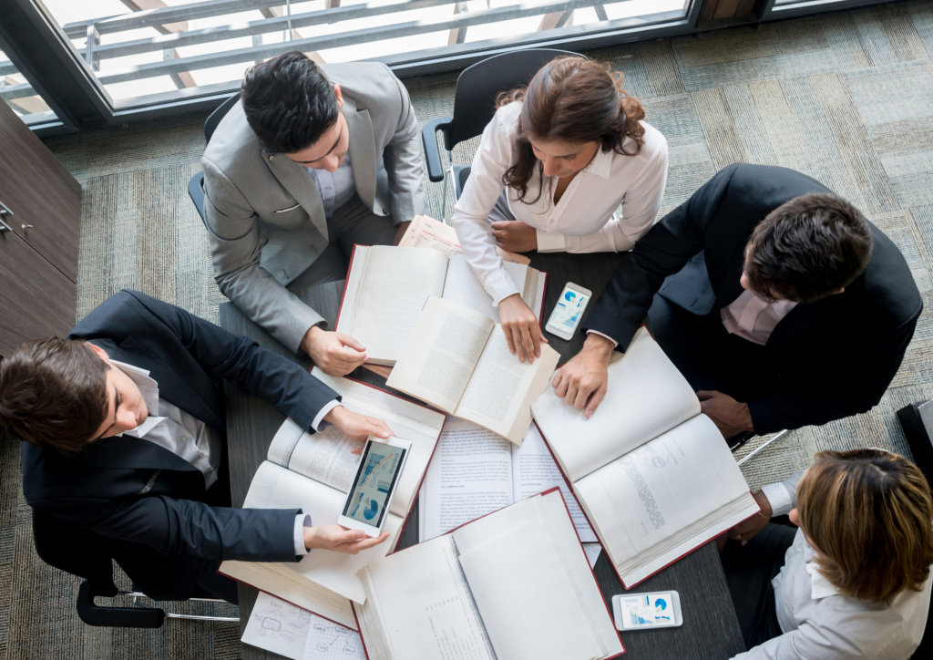 people sitting at a desk with books