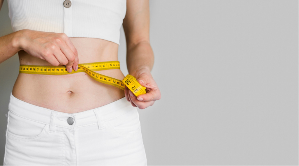 woman measuring her waist with tape measure